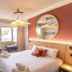 Bhoma Bourges - Hôtel room in Bourges with bed, desk, wall TV and round mirror