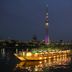 Tokyo Bay Shiomi Prince Hotel in Tokyo with a lit boat on the water and Tokyo Skytree at night