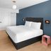 evo Hotel Tahoe City guest room with king bed, desk, wall-mounted TV and blue accent wall