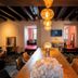Le Moulin de la Wantzenau dining room with long wooden table, pendant lights and black ceiling beams