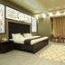 Safir Hotel in Dushanbe guest room with king bed, sitting area, wall-mounted TV and patterned rug.