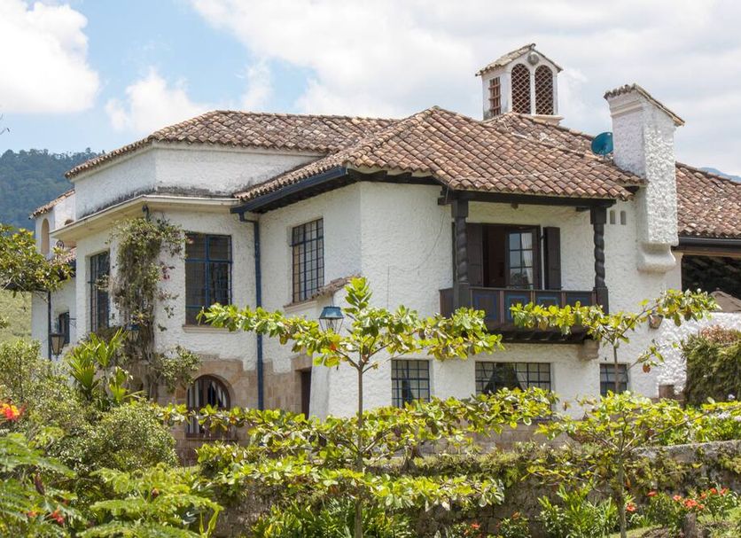 El Refugio Hotel & Spa in Sasaima, white villa with tiled roof, balconies, and lush garden