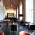 Hotel The Lodge Vilvoorde lounge with brick arches, black seating, and large arched windows