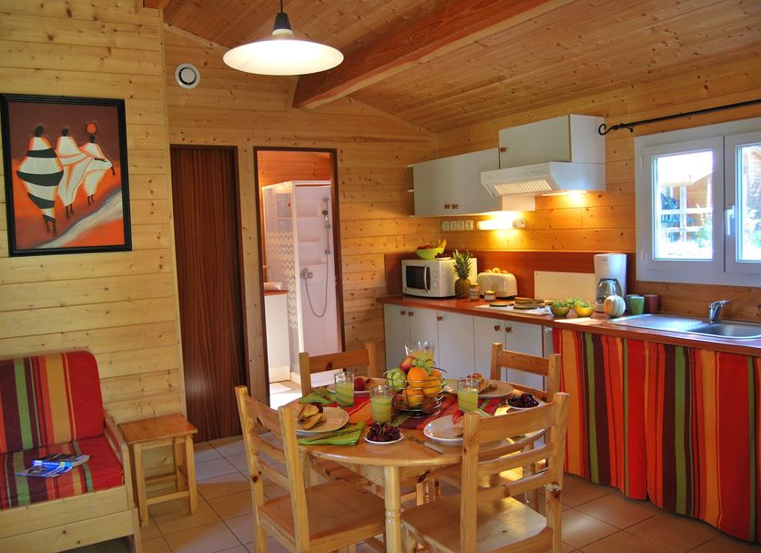 Lagrange Vacances Les Ségalières kitchen-dining area in Gramat with striped furnishings and wooden ceiling