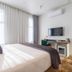 The Grosvenor, Timaru hotel room with king bed, wall-mounted TV and bright curtains