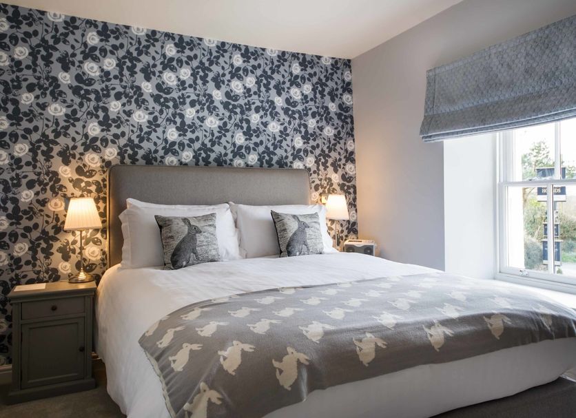 Hare & Hounds in Kendal bedroom with floral wallpaper, double bed, bedside lamps and window view