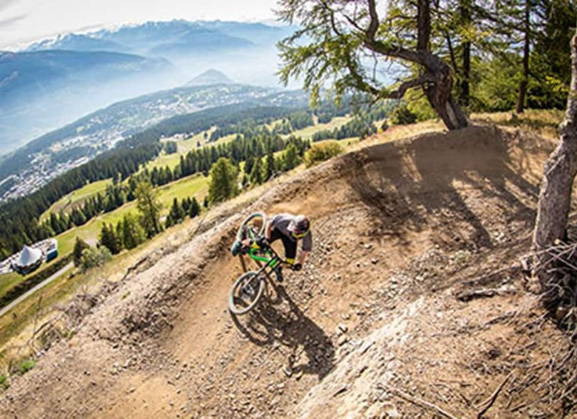 Crans-Montana Youth Hostel in Crans-Montana with mountain bikers on a scenic downhill trail