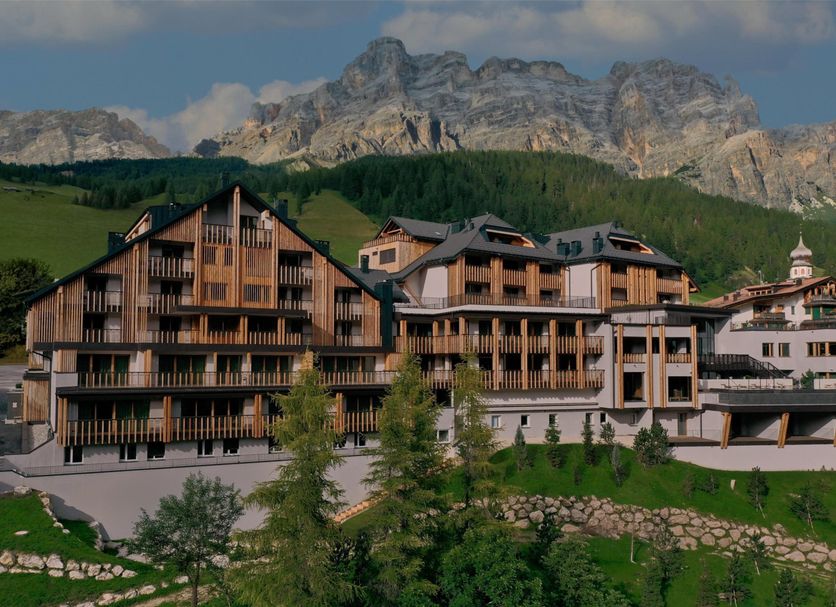 Aman Rosa Alpina in Badia/Abtei with alpine chalet-style buildings and mountain backdrop