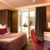 Hôtel Baume in Paris guest room with king bed, desk, and balcony doors to a courtyard