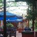 Hotel Beltran in Colonia del Sacramento patio with blue umbrellas, tables, chairs and lush greenery