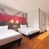 ibis Beijing Dongdaqiao room with two beds, gray sofa and red accents in Beijing