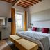 Relais Villa Grazianella Una Esperienze room in Acquaviva with bed, window, desk and bench seating
