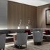 AC Hotels by Marriott Bologna lounge with curved banquette seating, round tables and framed wall art