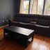 Nwk 457 Room 111-A in Newark with dark sofa, coffee table, hardwood floor, and window light.