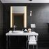 The Sound Hotel Seattle Belltown bathroom with black tile, walk-in shower, vanity, and mirror in Seattle