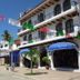 Hotel Casa Vieja in Puerto Escondido with balconies, blue awnings, and a street view