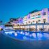 Apartamentos Sal Rossa in Sant Josep de sa Talaia with a lit outdoor pool and beachfront terrace at dusk