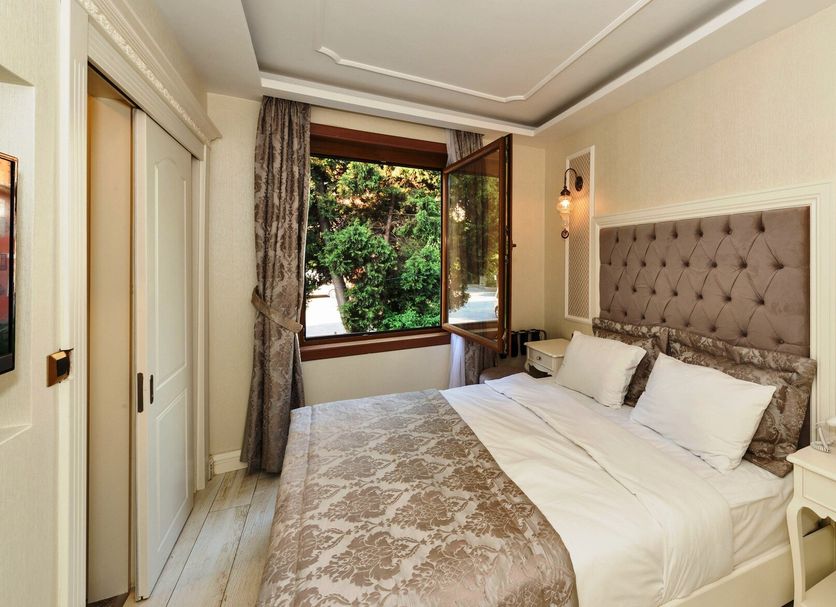 Zeynep Sultan Hotel Istanbul room with tufted bed and open window to greenery