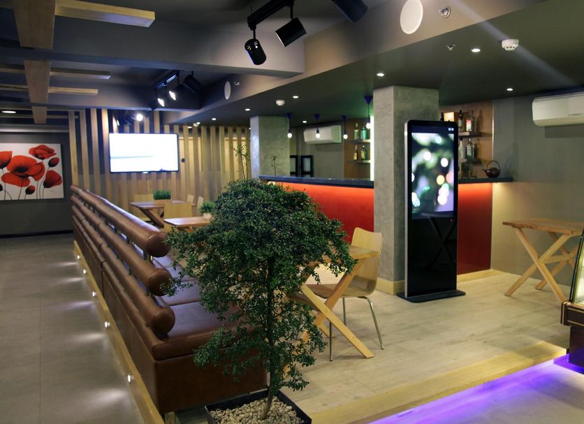 Guijo Suites Makati lobby lounge with seating, digital display, and purple floor lighting in Makati