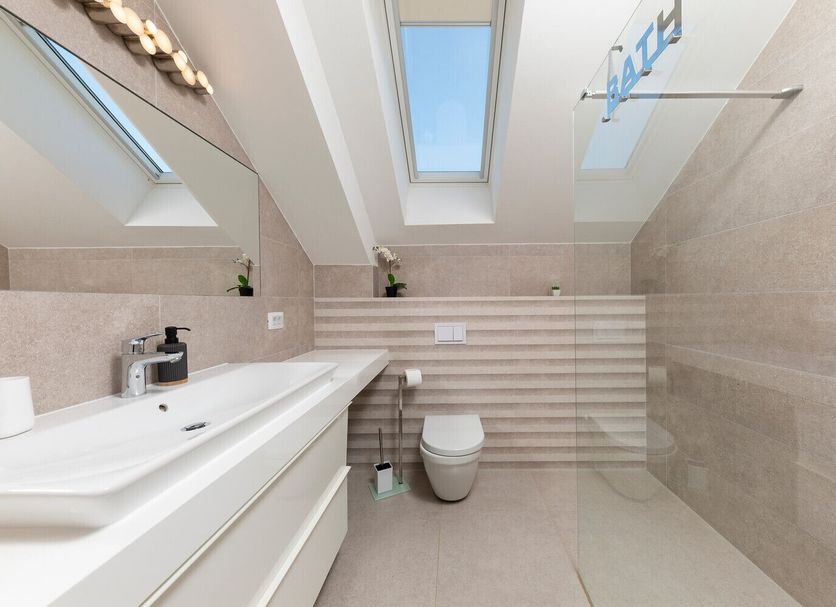 Villa Mediterranea in Bol bathroom with skylights, tiled walls, walk-in shower and wall-mounted toilet