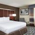 DoubleTree by Hilton Raleigh Crabtree Valley guest room with king bed, lamps, and patterned curtains in Raleigh