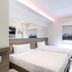 Easy Planet Bangkok Surawong room with two twin beds, wall-mounted TV, and Bangkok skyline art in Bangkok