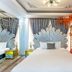 Mai Hotel Hanoi room with large fan-shaped headboard, mirrored wall, and red decor accent