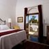 Eremo Della Giubiliana bedroom in Ragusa with open door to terrace and garden view