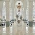 Hilton Salwa Beach Resort & Villas lobby in Doha with arched columns, chandeliers, and glossy marble floors