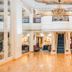 The Dilly London grand lobby with chandelier, polished wood floor, and central staircase