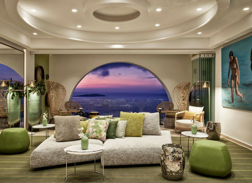 Myconian Korali Relais & Chateaux lounge in Mykonos with sea-view arch window and sunset view