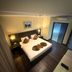 The BCC Hotel & Residence, Batam guest room with king bed, bedside lamps and wall-mounted TV