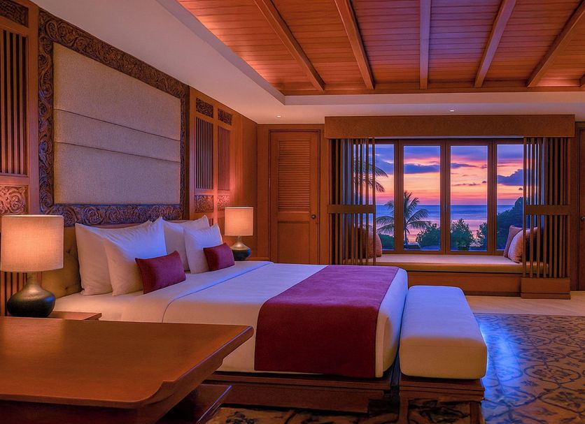 Swarga Suites Bali Berawa, North Kuta bedroom with ocean sunset view and wooden decor