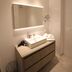 Adagio Amsterdam City South bathroom with floating vanity, lit mirror and beige tile in Amstelveen