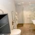 Hotel Herbers Efemir Gmbh bathroom in Südbrookmerland with walk-in glass shower and wall-mounted sink