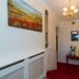 Aisleigh Guest House in Leitrim hallway with red carpet, chandelier, wall art and a small console table
