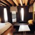 Ristolocanda Grani di Pepe in Flaibano: cozy guest room with bed, sofa, wall TV and exposed beams