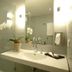 Zollamt Design Hotel Kaiserslautern bathroom with glass shower, sink, mirror, and orchid