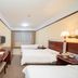 Hubin Bubugao Hotel in Qingyuan guest room with three beds, TV, desk and window with curtains