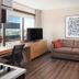 Canal Street, New Orleans guest room with sofa, desk, TV and city view through large window