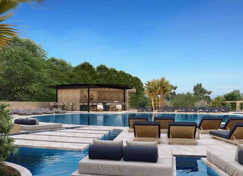 Achousa in Faliraki: outdoor pool with lounge seating, cabanas, and palm trees under a clear blue sky