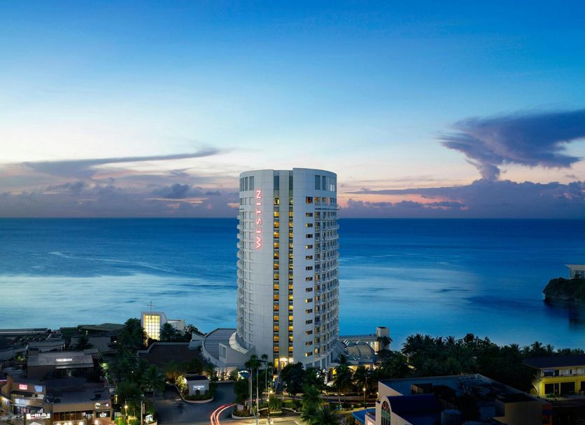 The Westin Resort Guam in Tamuning with a tall tower overlooking the ocean at sunset