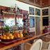 Mike's Dauin Dive Resort bar with fruit display, liquor shelves, and wicker bar stools in Dauin