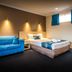 Park Beach Resort Motel room in Coffs Harbour with blue sofa, bed and small high windows