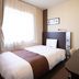 Comfort Hotel Tomakomai guest room with single bed, desk, and TV in Tomakomai