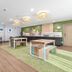 Spark by Hilton Harrisonburg University Area breakfast area with tables, green chairs and buffet counter