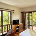 Riverhouse Resort, Mae Sariang guest room with balcony doors, forest view, TV and wooden bed