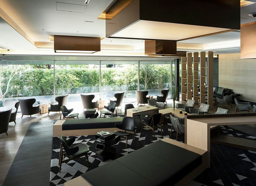 Cross Hotel Kyoto in Kyoto lounge with modern seating, patterned rug, and floor-to-ceiling windows