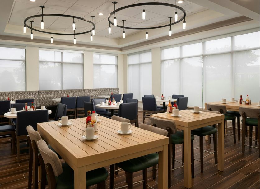 Hilton Garden Inn Richmond South/Southpark dining area with wooden tables and dark chairs in Colonial Heights
