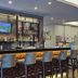 d'primahotel Kualanamu Medan bar area with high stools and backlit shelves in Medan